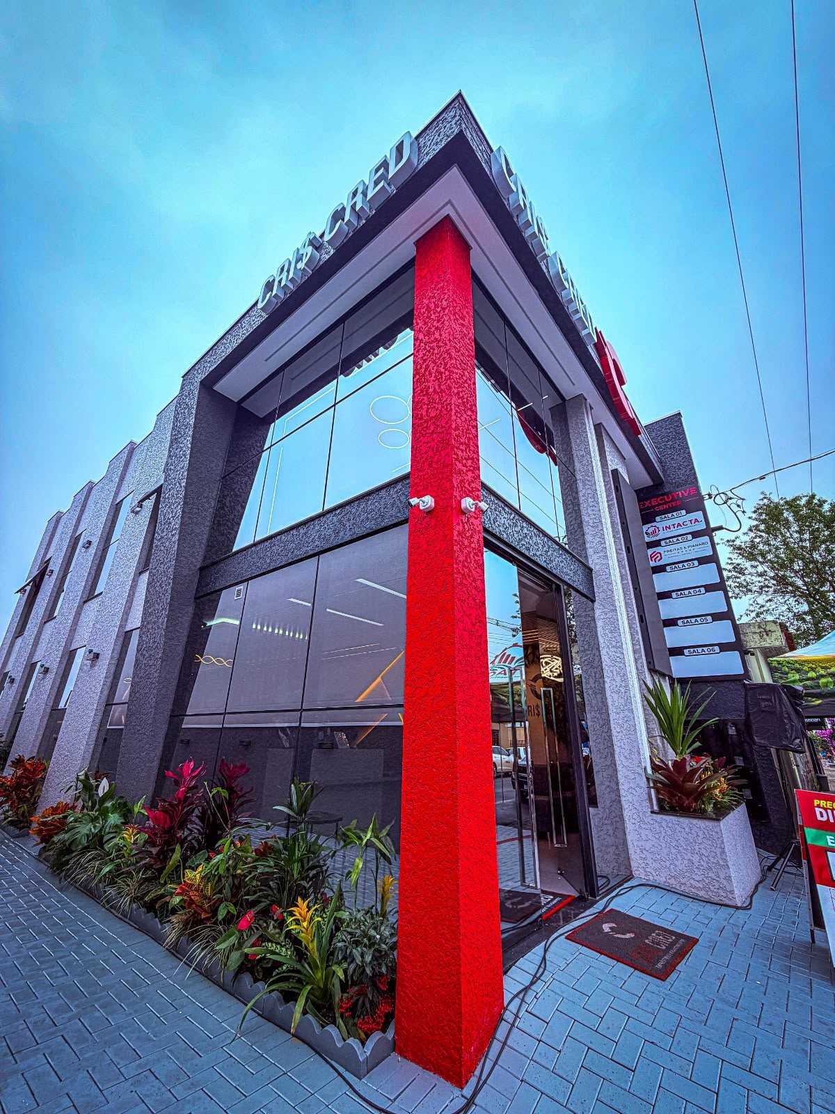 Sede da Cris Cred à noite, fachada iluminada em vermelho